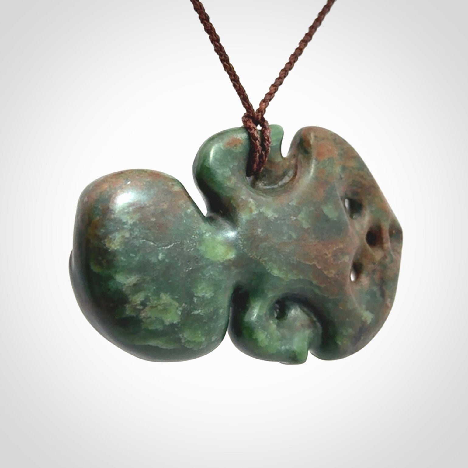 This is a large sized tiki - carved from gorgeous Marsden jade with Pāua Shell eyes. The craftsmanship is superb, this piece is as well carved as any we have seen. We have plaited an adjustable brown cord for this piece.&nbsp;