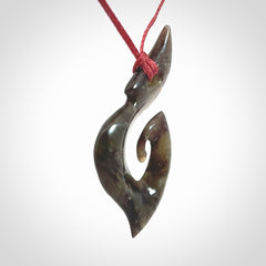 This photo shows a contemporary koru pendant carved from New Zealand Totoweka Jade. We provide this piece with an adjustable red cord.