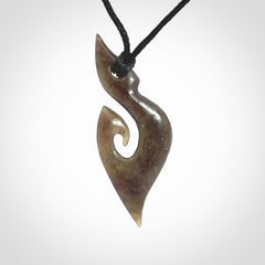 This photo shows a contemporary koru pendant carved from New Zealand Totoweka Jade. We provide this piece with a black fixed length cord.