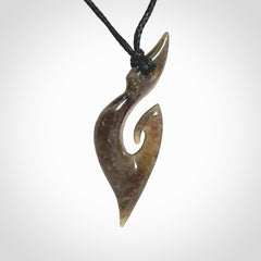 This photo shows a contemporary koru pendant carved from New Zealand Totoweka Jade. We provide this piece with a black fixed length cord.