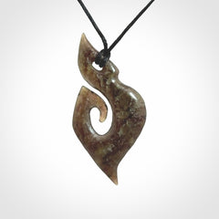 This photo shows a contemporary koru pendant carved from New Zealand Totoweka Jade. We provide this piece with a black fixed length cord.