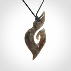 This photo shows a contemporary koru pendant carved from New Zealand Totoweka Jade. We provide this piece with a black fixed length cord.