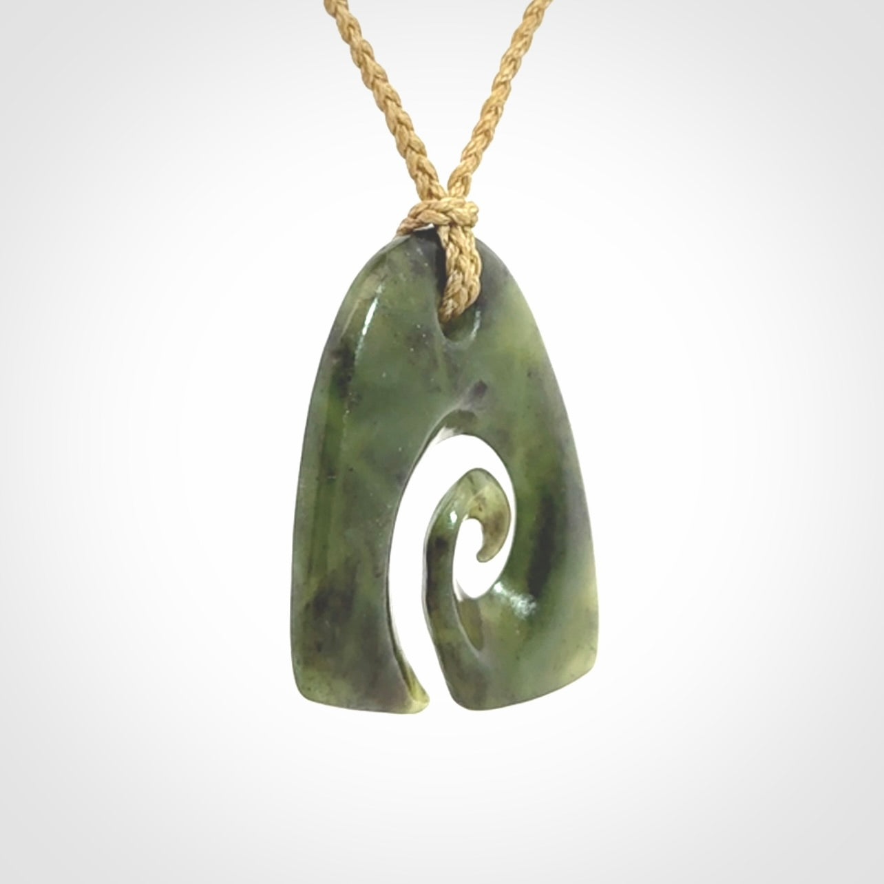 This photo shows a contemporary koru pendant carved from New Zealand Jade. We provide this piece with a tan fixed length cord.