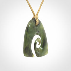 This photo shows a contemporary koru pendant carved from New Zealand Jade. We provide this piece with a tan fixed length cord.