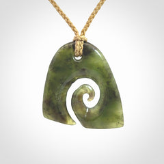 This photo shows a contemporary koru pendant carved from New Zealand Jade. We provide this piece with a tan fixed length cord.