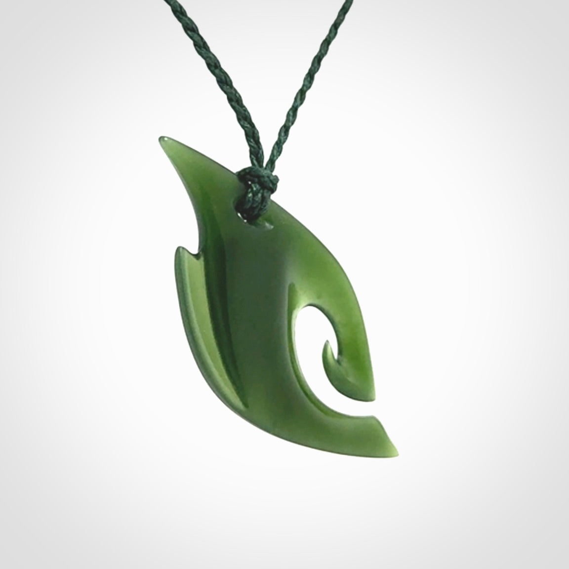 This photo shows a koru pendant carved from New Zealand Jade. We provide this piece with an adjustable green cord.