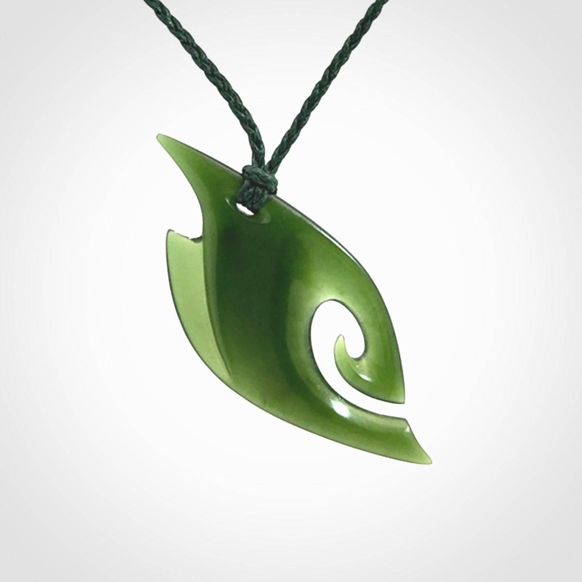 This photo shows a koru pendant carved from New Zealand Jade. We provide this piece with an adjustable green cord.