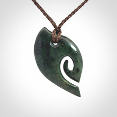 This photo shows a koru pendant carved from New Zealand Jade. We provide this piece with an adjustable brown cord.