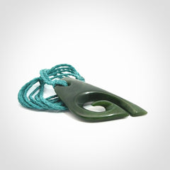 This photo shows a koru pendant carved from New Zealand Jade. We provide this piece with an adjustable blue cord.