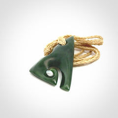 This photo shows a koru pendant carved from New Zealand Jade. We provide this piece with an adjustable oat cord.