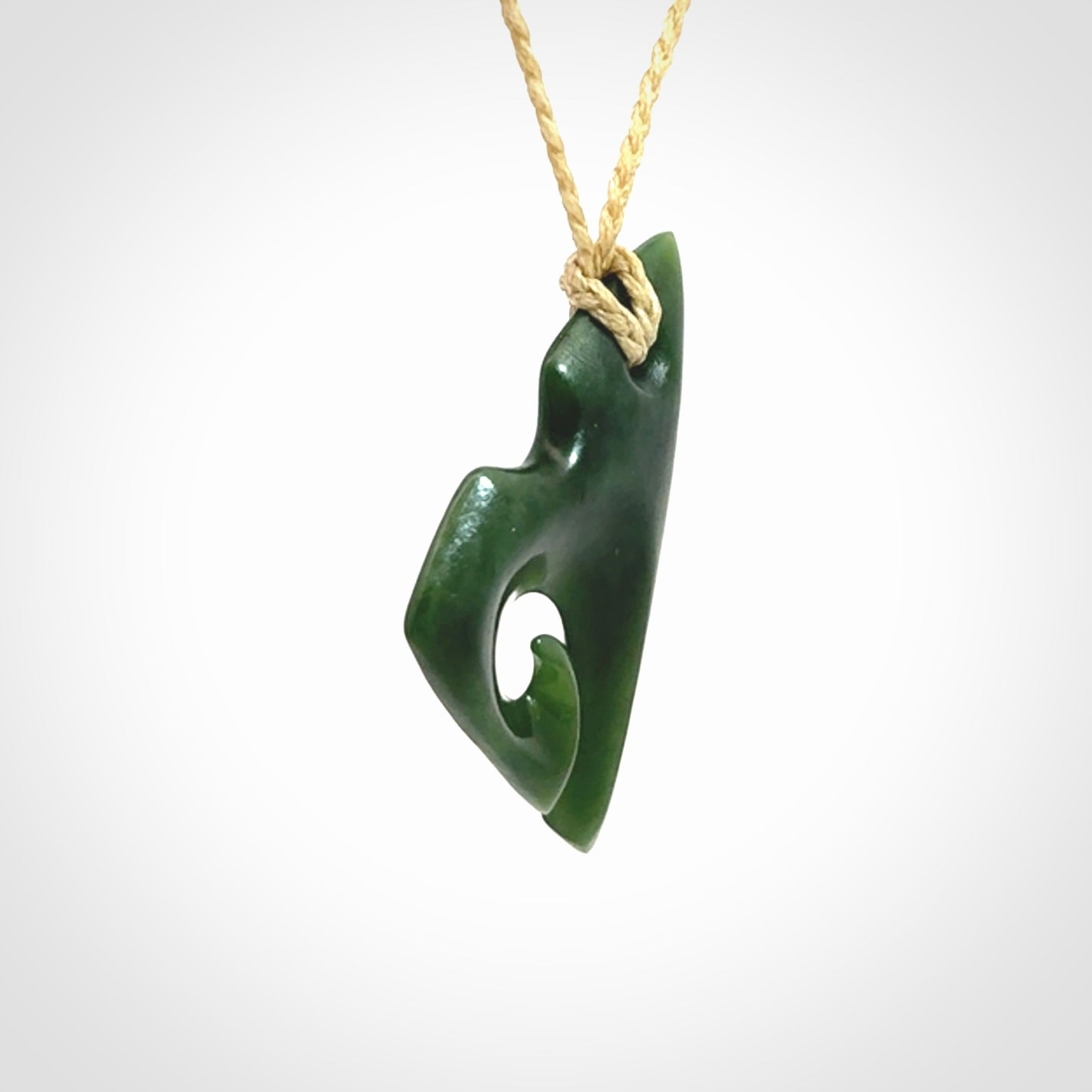 This photo shows a koru pendant carved from New Zealand Jade. We provide this piece with an adjustable oat cord.