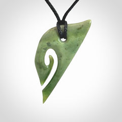 This photo shows a koru pendant carved from New Zealand Jade. We provide this piece with an adjustable black cord.