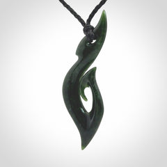 This photo shows a large hook with koru pendant carved from New Zealand Jade. The artist, Shaun Gardiner, has carved this beautifully. We provide this piece with an adjustable black cord. This is a fantastic work of art, we have one only.
