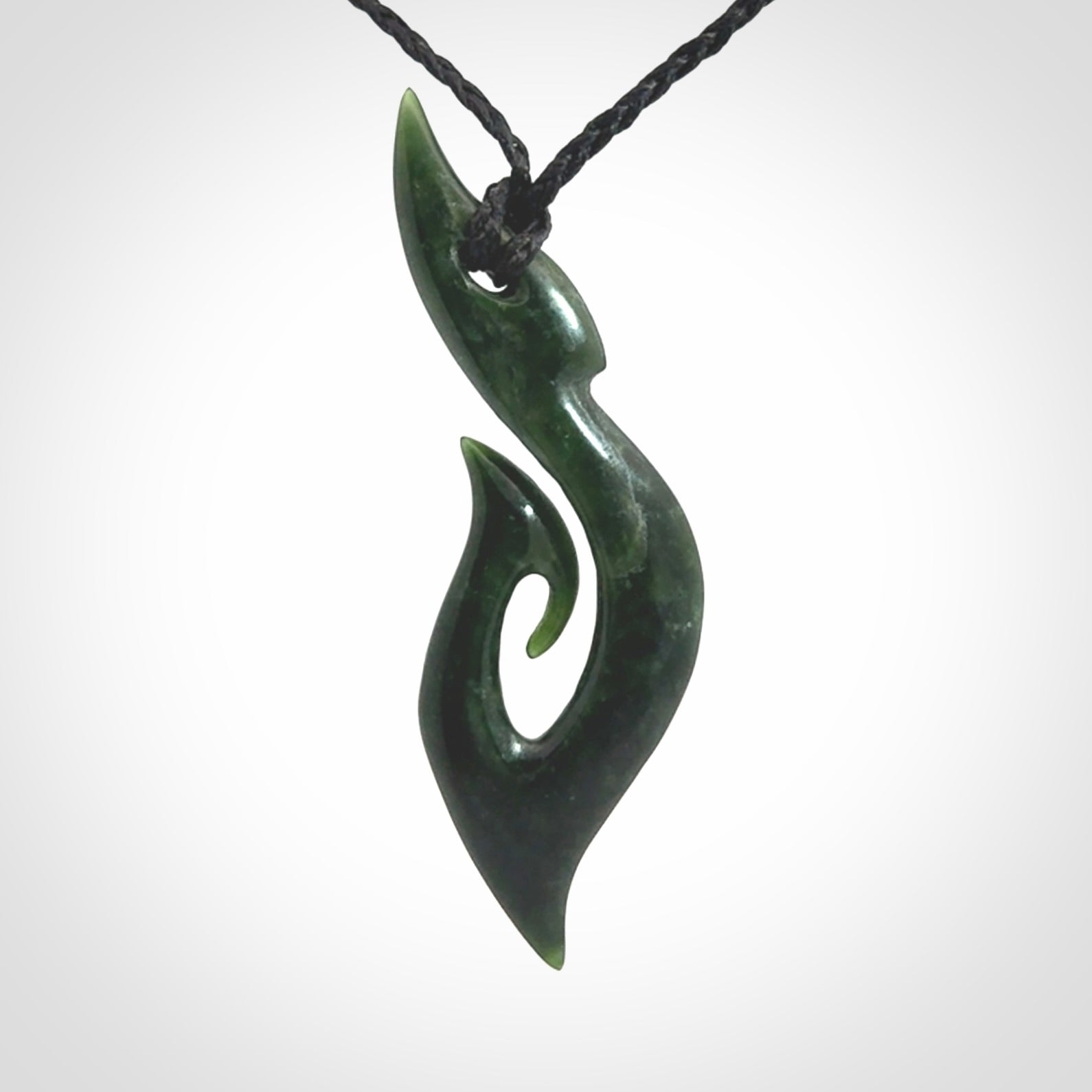 This photo shows a large hook with koru pendant carved from New Zealand Jade. The artist, Shaun Gardiner, has carved this beautifully. We provide this piece with an adjustable black cord. This is a fantastic work of art, we have one only.