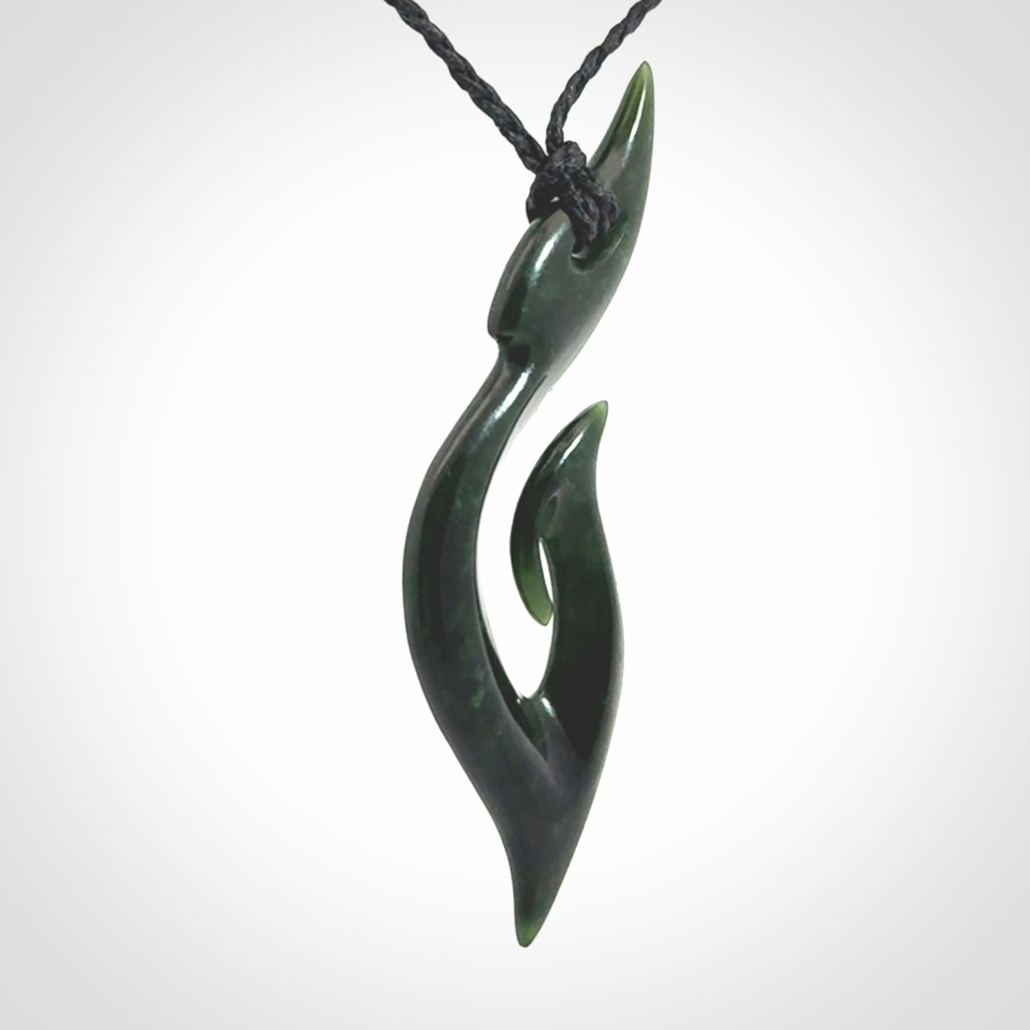 This photo shows a large hook with koru pendant carved from New Zealand Jade. The artist, Shaun Gardiner, has carved this beautifully. We provide this piece with an adjustable black cord. This is a fantastic work of art, we have one only.