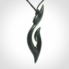 This photo shows a large hook with koru pendant carved from New Zealand Jade. The artist, Shaun Gardiner, has carved this beautifully. We provide this piece with an adjustable black cord. This is a fantastic work of art, we have one only.