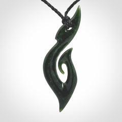 This photo shows a large hook with koru pendant carved from New Zealand Jade. The artist, Shaun Gardiner, has carved this beautifully. We provide this piece with an adjustable black cord. This is a fantastic work of art, we have one only.