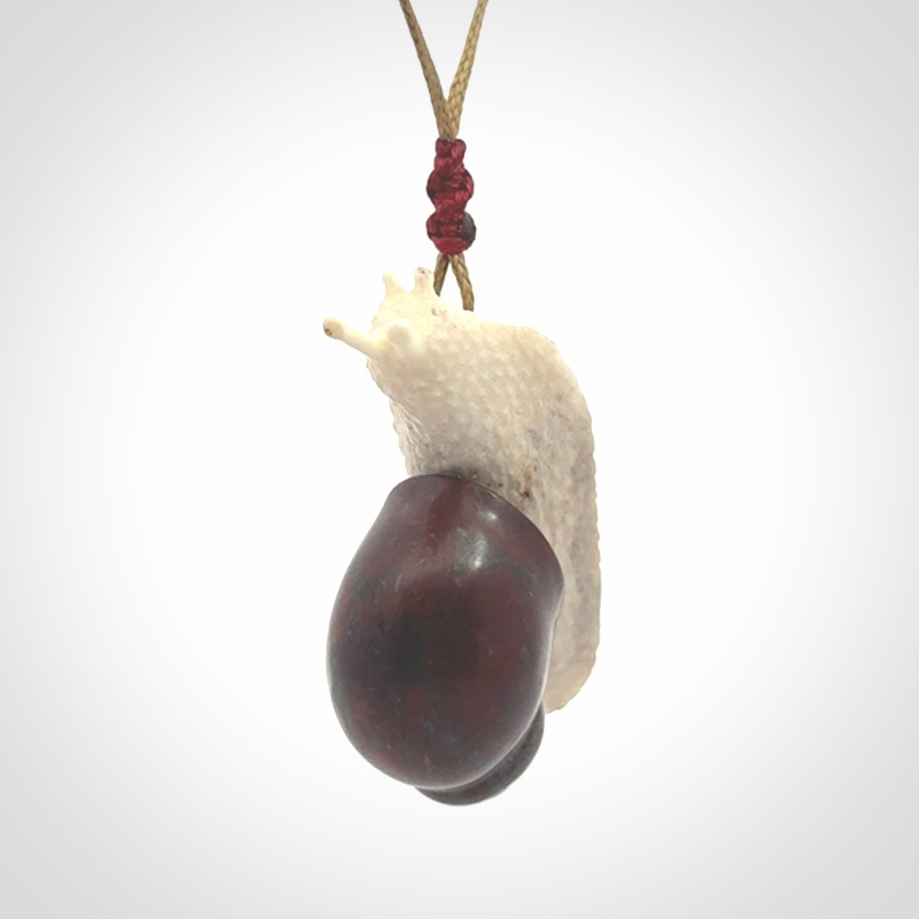 Snail design pendant carved in red jasper with bone. Real jasper and bone jewellery for sale online with NZ Pacific.