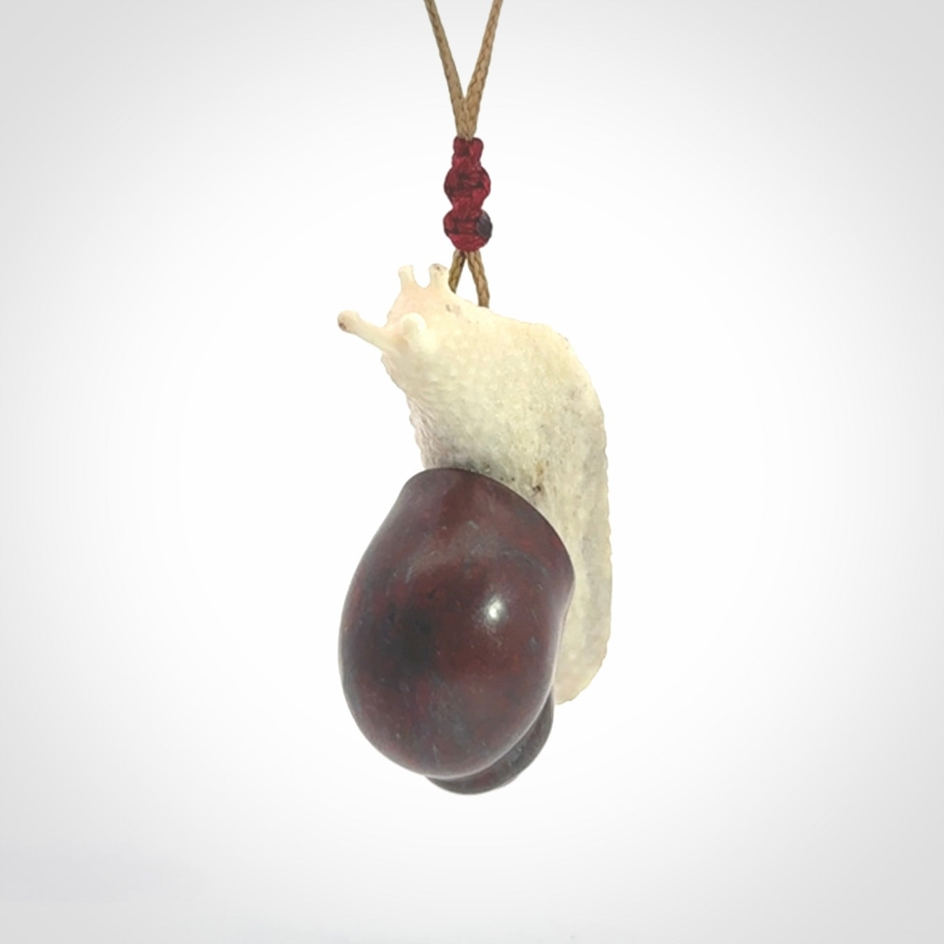 Snail design pendant carved in red jasper with bone. Real jasper and bone jewellery for sale online with NZ Pacific.