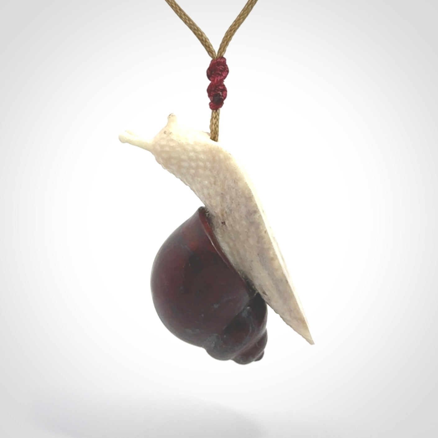 Snail design pendant carved in red jasper with bone. Real jasper and bone jewellery for sale online with NZ Pacific.