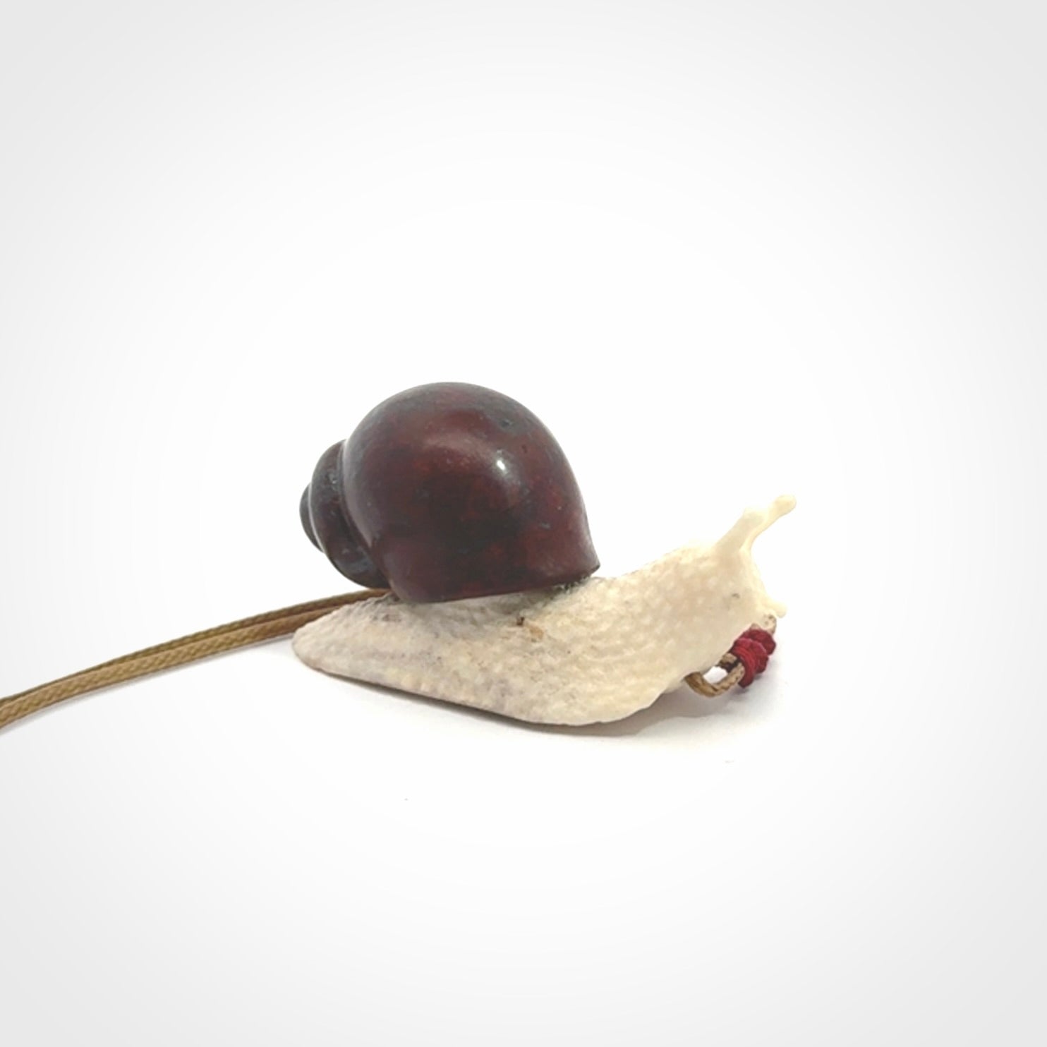Snail design pendant carved in red jasper with bone. Real jasper and bone jewellery for sale online with NZ Pacific.
