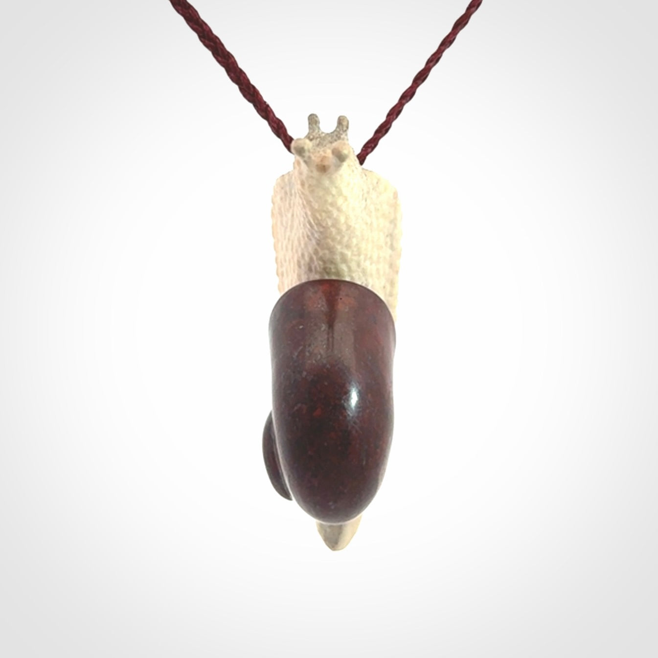 Snail design pendant carved in red jasper with deer antler. Real jasper and bone jewellery for sale online with NZ Pacific.