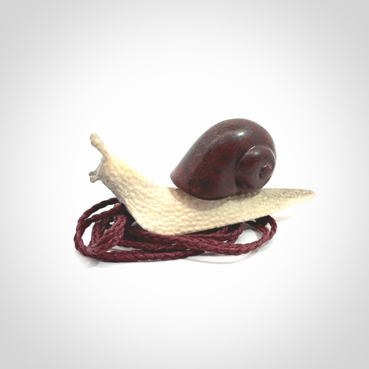 Snail design pendant carved in red jasper with deer antler. Real jasper and bone jewellery for sale online with NZ Pacific.