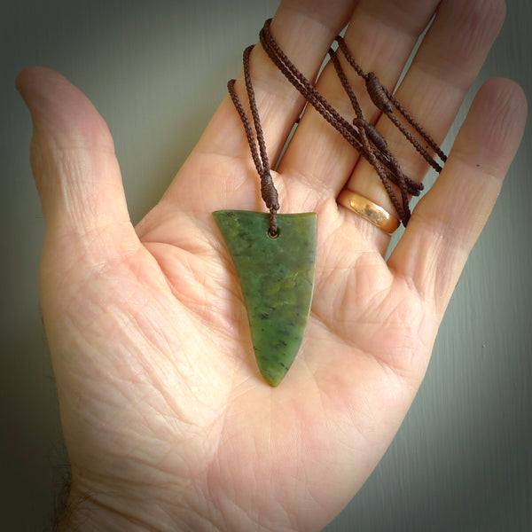 This photo shows a medium jade drop shaped pendant. It a a lovely varied green and orange New Zealand Marsden jade. The cord is a four plait brown and is adjustable in length. One only medium, contemporary drop necklace from Jade, by Ric Moor.