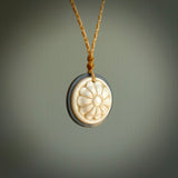 Hand carved natural bone with buffalo horn contemporary disc pendant with creative and unique carvings on the front face of each individual piece. Delivered with an adjustable cord.