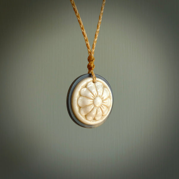 Hand carved natural bone with buffalo horn contemporary disc pendant with creative and unique carvings on the front face of each individual piece. Delivered with an adjustable cord.
