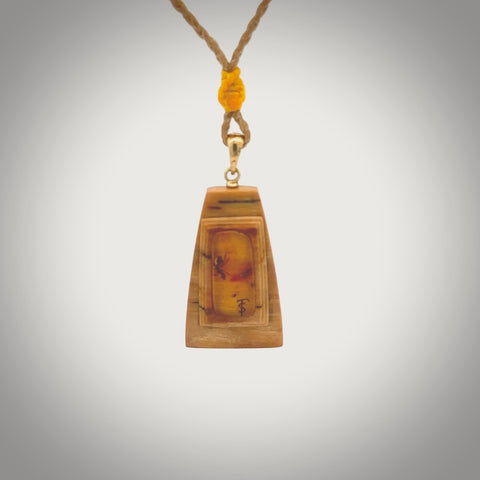 This is a hand carved woolly mammoth tusk with amber contemporary pendant. It is made from woolly mammoth tusk with amber. This is a small sized necklace and is a very unique, one only, pendant that is a collectors piece. Hand carved by New Zealand artist, Sami.