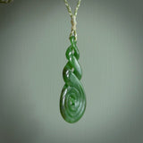 Ross Crump triple twist with koru pendant. Hand carved from rare New Zealand jade this is a beautiful pounamu pendant. The cord is hand plaited in green and white colours and is length adjustable. It has a floret in white. It is a delicate and very beautiful greenstone pendant. For sale online by NZ Pacific.