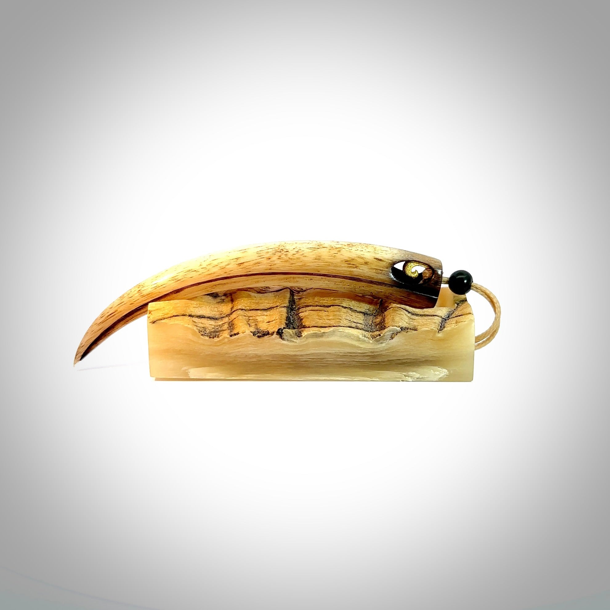 This is a hand carved rams horn huia bird beak pendant. It is made from rams horn with 24 carat gold leaf and jade toggle. This is a large sized necklace and is a very unique, one only, pendant that is a collectors piece. Hand carved by New Zealand artist, Sami.