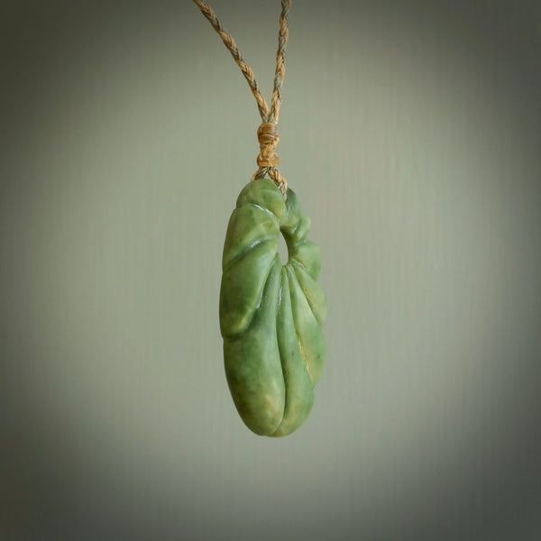 This picture shows a contemporary drop shaped pendant, hand carved from New Zealand flower jade. We will provide this with an adjustable plaited cord. Hand crafted stunning New Zealand Marsden Flower Jade drop pendant by Ana Krakosky.