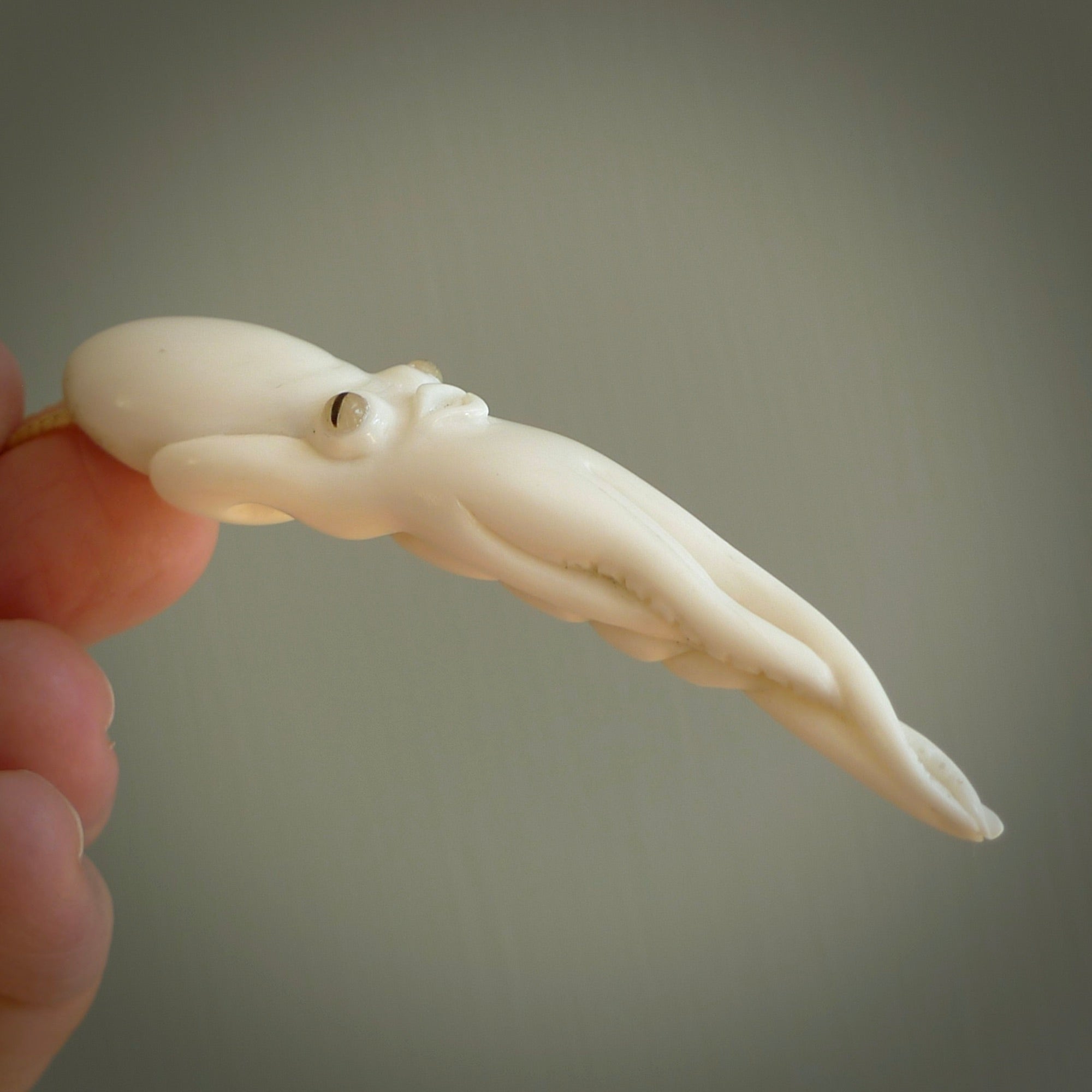Hand carved octopus pendant in resting pose. This piece has been carved in incredible detail from bone. The artist is Fumio Noguchi, a renowned New Zealand bone carver who carves pieces for NZ Pacific. These unique bone pendants are for sale online at nzpacific.com One only collectors item for lovers of the ocean and octopus.