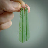 This picture shows New Zealand Pounamu, jade feather earrings with sterling silver hooks. Hand made unique and contemporary feather earrings by Kerry Thompson. Hand carved here in New Zealand from New Zealand Jade. One pair only.