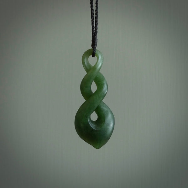This piece is a fine, delicate drop shaped, double twist pendant. It was carved for us by Ric Moor from a lovely deep green piece of New Zealand jade. It is suspended on an black four plaited braided cord that is length adjustable.