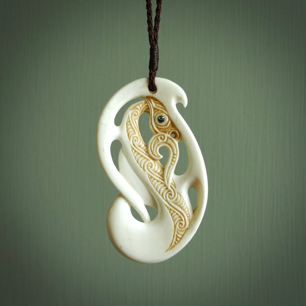Bone carving of a taniwha. A three dimensional pendant carved in bone by Andrew Doughty. One only taniwha carving for men and women. Provided with an adjustable cord.