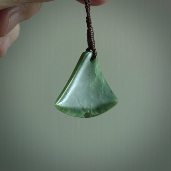 This is a lovely New Zealand Jade, pounamu drop pendant. Hand carved for us by Ric Moor. It is bound with an adjustable brown coloured cord which is length adjustable. Free worldwide shipping.