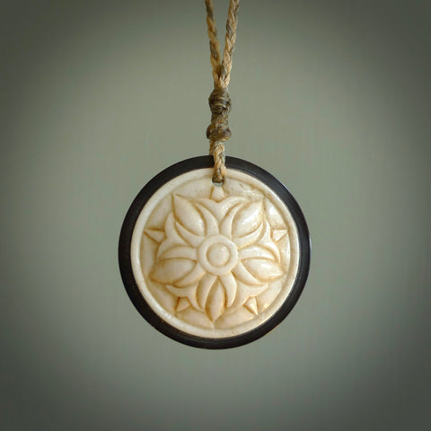 Hand carved natural bone with buffalo horn contemporary disc pendant with creative and unique carvings on the front face of each individual piece. Delivered with an adjustable cord.