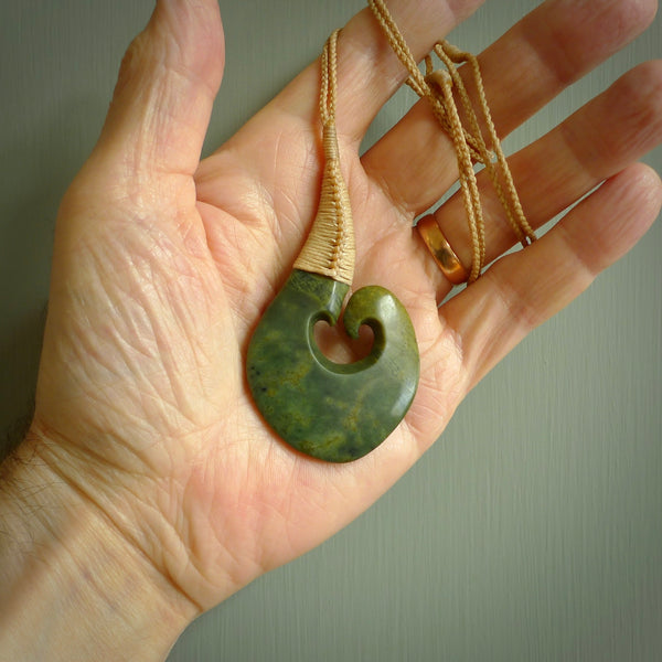 This matau, with koru, is carved from a very striking New Zealand jade. It is both intricate and simple in design - it has hidden folds and smooth curves. A piece to be worn or displayed - the carving and the jade are both magnificent. Hand made by Donna Summers.