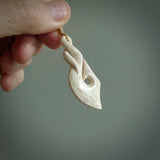 Hand carved stellar intricate twist carving with hook design. A stunning work of art. This pendant was hand carved by Fumio Noguchi, in Bone. A one off collectors item that has been hand crafted to be worn or displayed.
