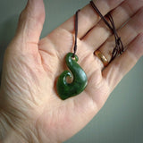 This picture shows a jade hook pendant, also called a hei-matau, carved for us in New Zealand jade. The carver is Ric Moor - and this is a beautiful example of his work. The cord is a four-plait, adjustable brown coloured necklace.