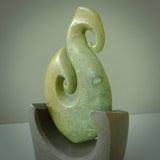Hand carved New Zealand Flower Jade Hook with Greywacke stand sculpture. Hand carved in New Zealand by Ric Moor. This is a one only sculpture and is a beautiful, large, display piece.
