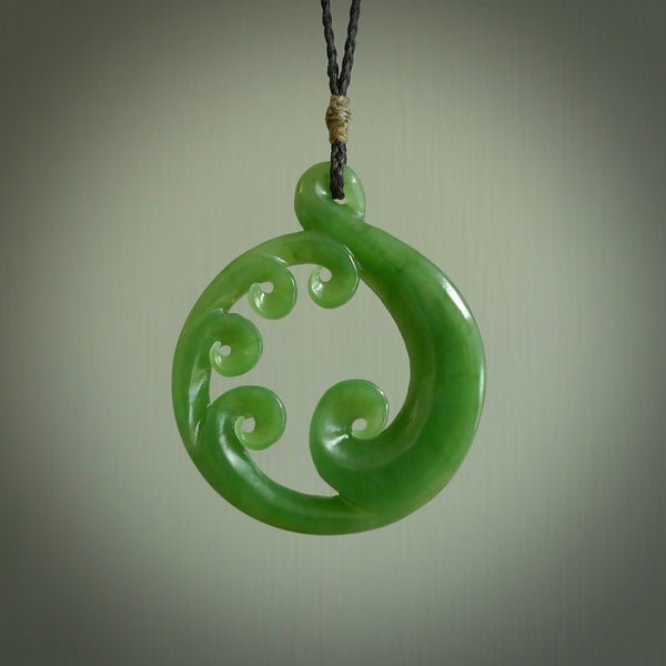 This picture shows a large, rolling koru design with five koru florets unfurling from the centre. Beautifully balanced and very finely carved. Backlit, light flows through the florets revealing the inner secrets of our favourite stone.