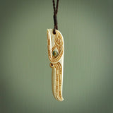 This picture shows a carved kāhu, hawk in bone. It is a drop shaped pendant. The artist has carved traditional decorative kowhaiwhai designs into the body and these run up the sides of the hawk. These have specific meanings. It is provided with a hand-plaited brown cord that is length adjustable. Shipping is included and we ship worldwide.