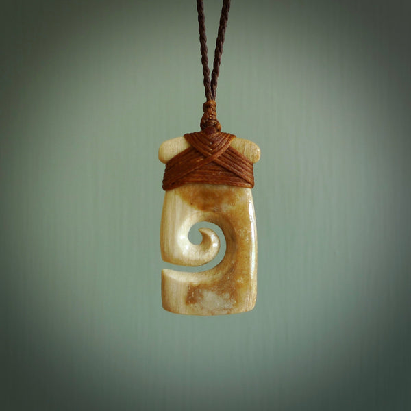 Hand carved Woolly Mammoth Tusk toki with koru pendant. Toki with koru necklace carved from ancient woolly mammoth tusk.
