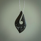 A hand carved large New Zealand Tangiwai Hook, Matau, necklace. The cord is a cosmos and blue moon grey colour and is length adjustable. A large sized hand made hook necklace by New Zealand artist Rueben Tipene. One off work of art to wear.