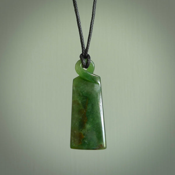 This pendant is a flower jade single twist. It is handcarved from New Zealand flower jade and has a mix of green, mint and pale gold colours interspersed throughout the stone. It has a fine twist, small and light. The cord is hand plaited and can be adjusted. The cord colour on this piece is Khaki. Two sizes available.