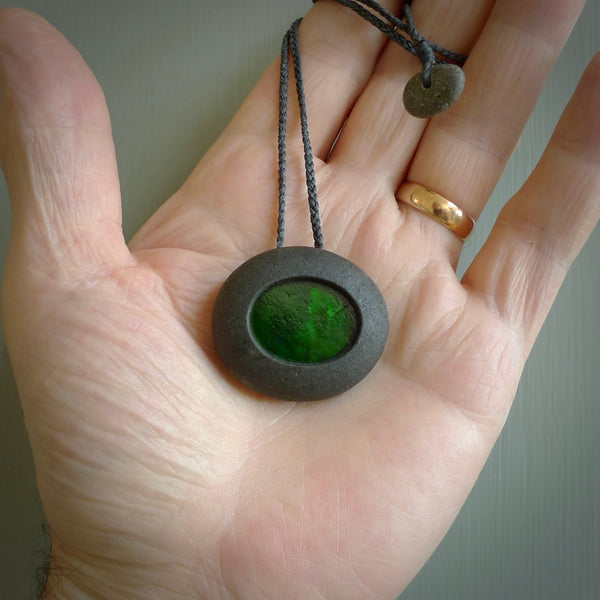 A drop pendant made from Onewa Stone - New Zealand Greywacke - with a fine green antique window glass insert spliced into the middle.